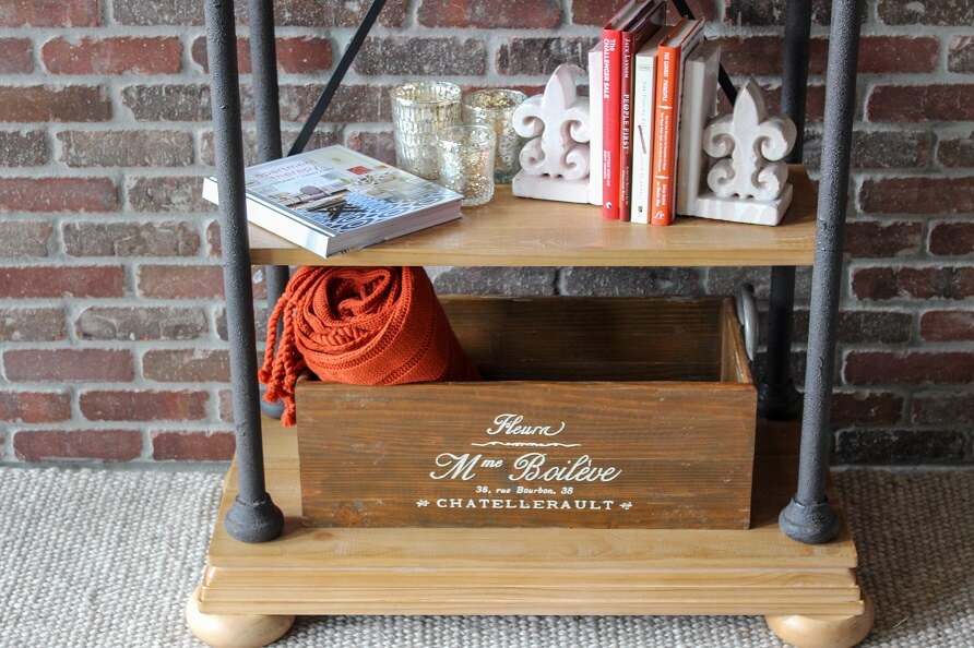 Last two shelves of a bookcase with bookends displayed as well as a box and books.