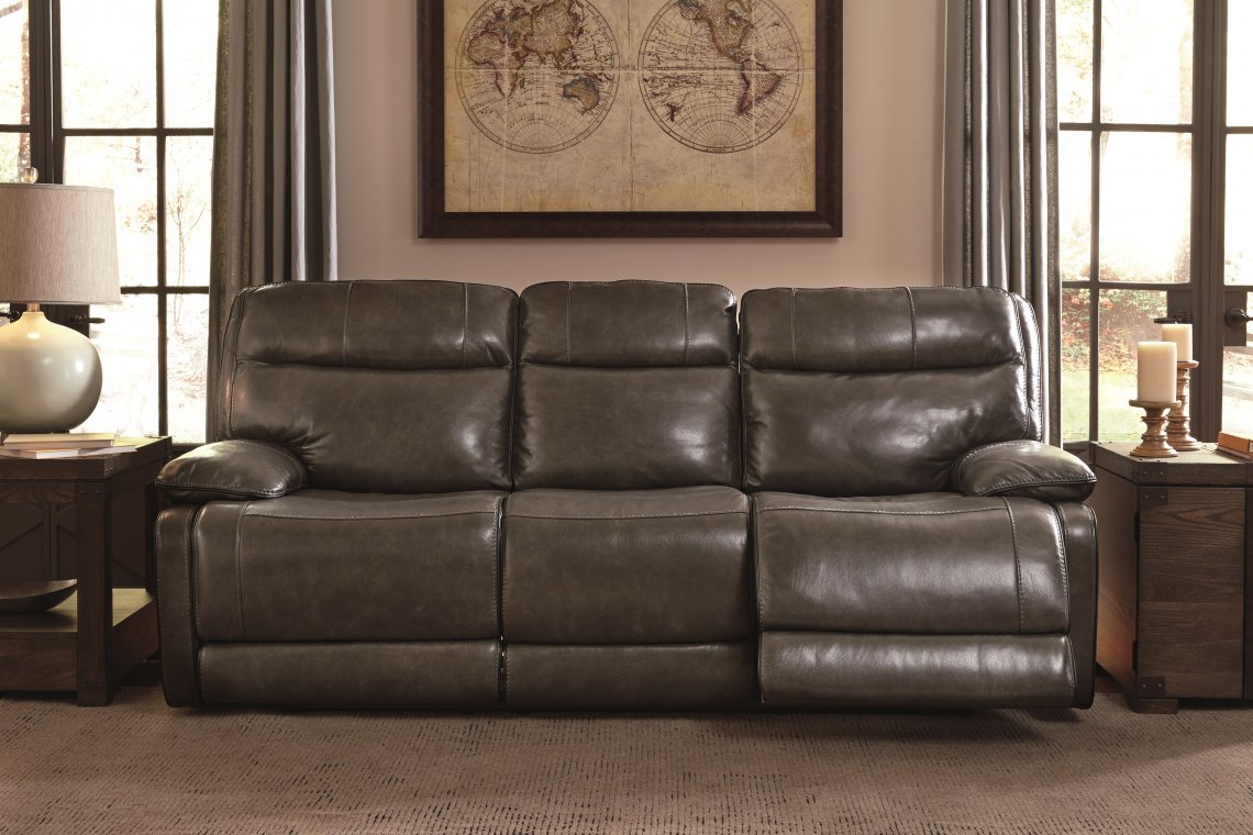 Leather reclining sofa with dim lights and masculine vibe with a map in a frame on a wall.