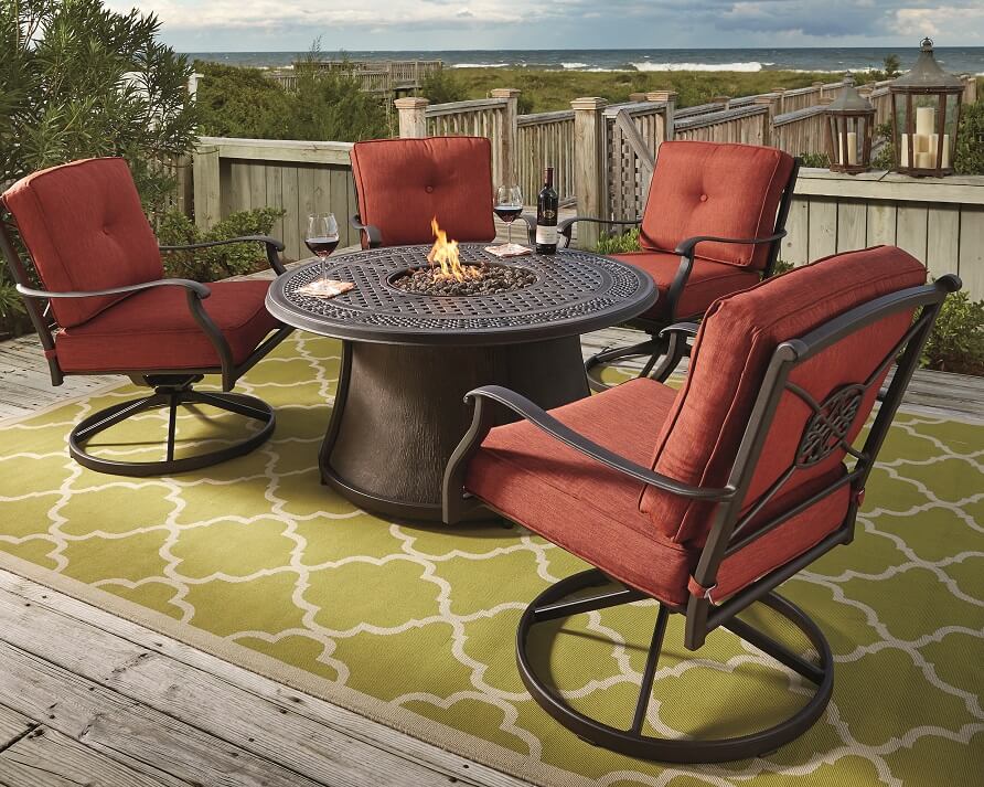 outdoor table and chair with built in fire place ona dock overlooking the beach