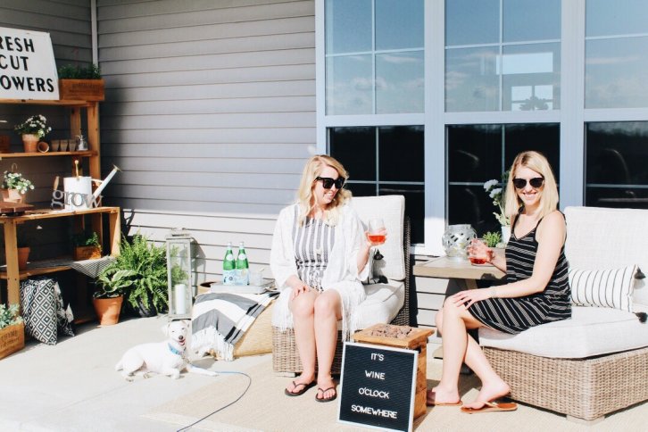 women on outdoor furniture with wine