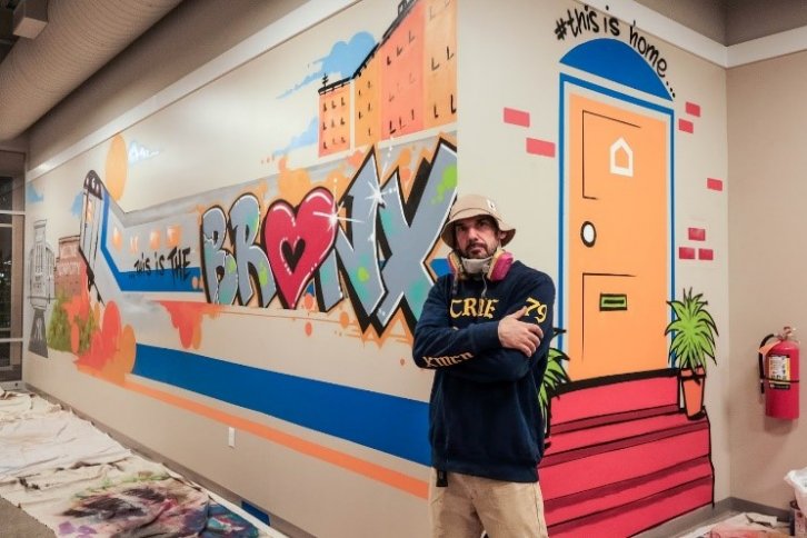 Man poses with mural.