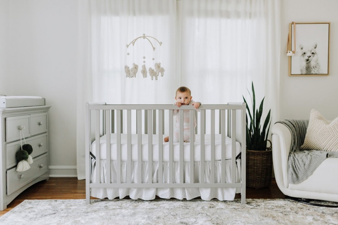 Baby standing in crib.