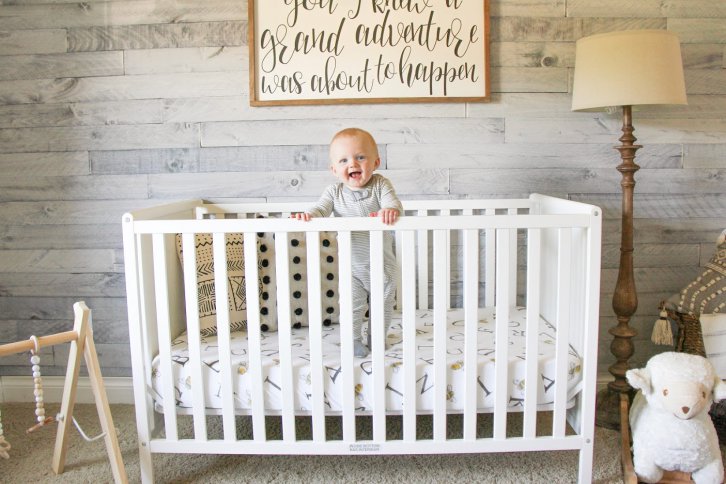 Oliver standing in crib.